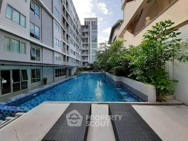 Modern apartment complex with inviting outdoor pool and lush greenery