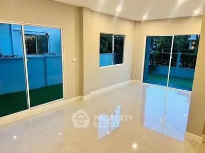 Spacious modern living room with large windows and glossy floor tiles