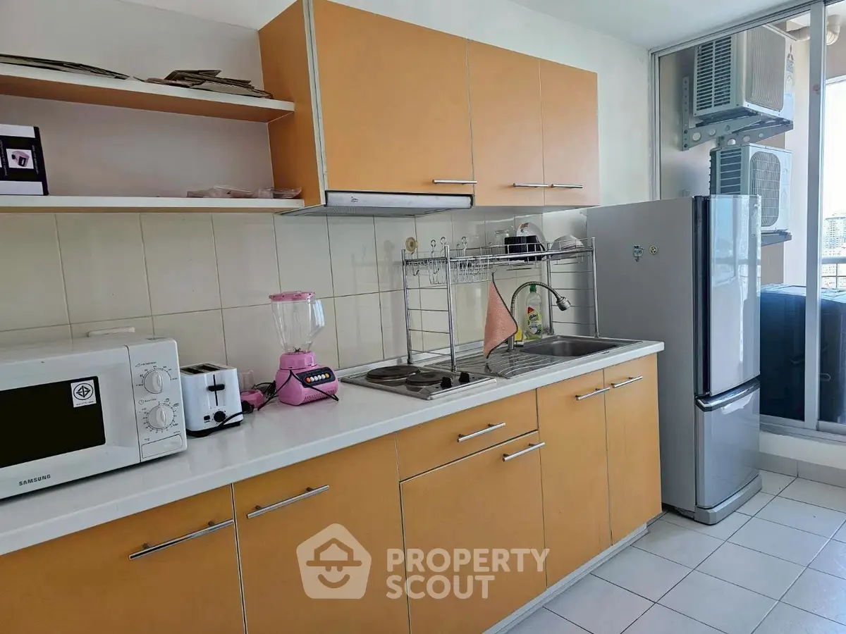 Modern kitchen with sleek cabinets, appliances, and ample counter space in a bright apartment.