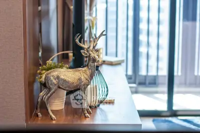 Stylish interior with decorative deer statue and modern furnishings near a bright window.