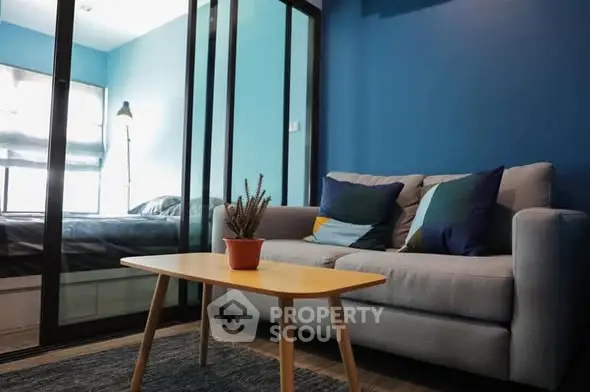 Modern living room with blue walls and cozy sofa in stylish apartment.