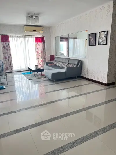 Spacious living room with modern decor and large windows for natural light.