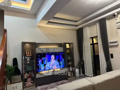 Modern living room with stylish ceiling lights and large TV, perfect for entertainment and relaxation.