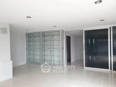 Spacious modern living room with glass sliding doors and ample natural light.