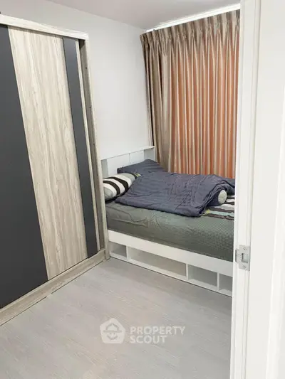 Cozy bedroom with modern wardrobe and stylish curtains, perfect for a comfortable living space.