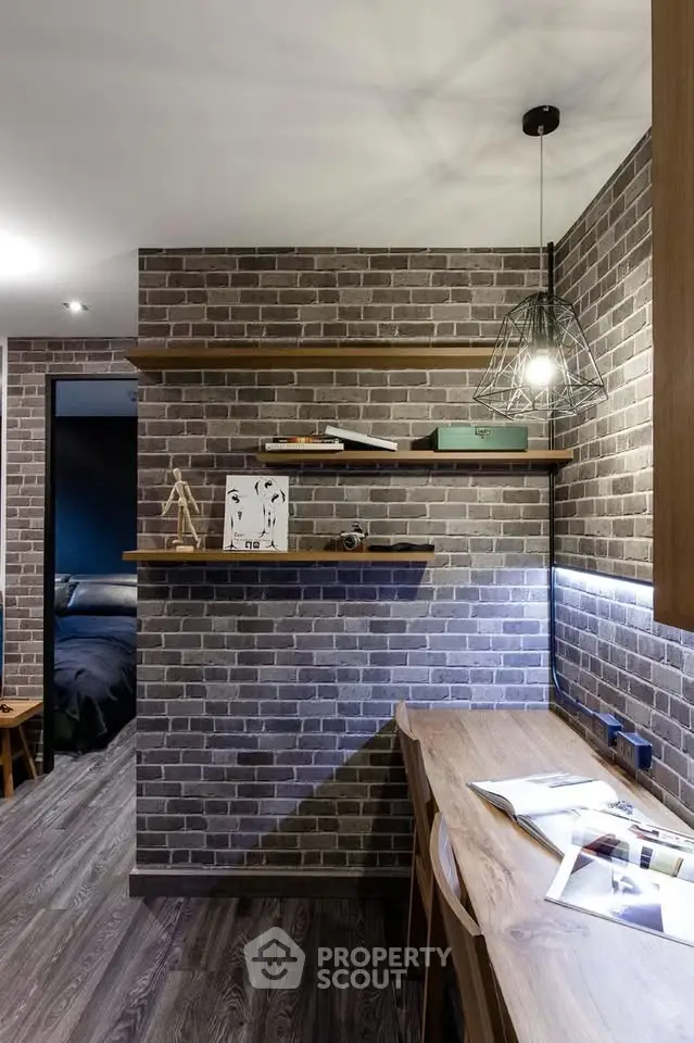 Stylish study area with brick wall, wooden shelves, and modern lighting in a cozy home interior.
