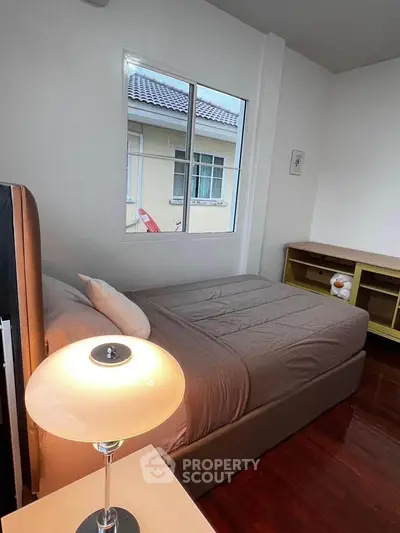 Cozy bedroom with modern lamp and window view in stylish home