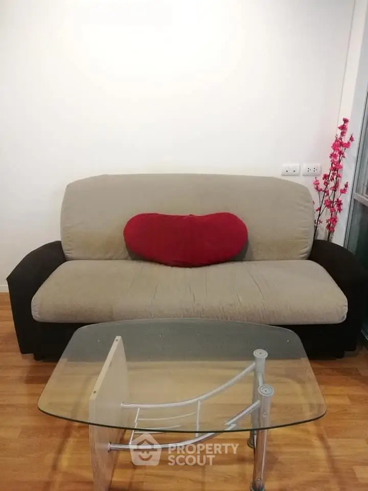 Cozy living room with modern sofa and glass coffee table, perfect for relaxation.