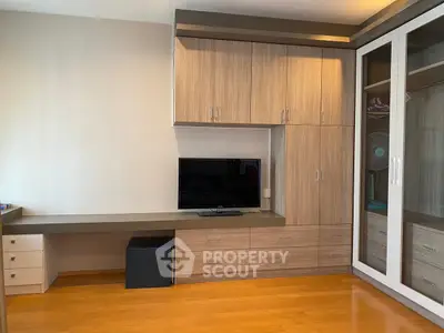 Modern bedroom with built-in wooden cabinets and sleek TV setup