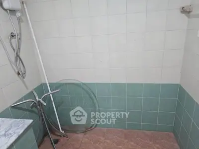 Simple bathroom with tiled walls and shower area