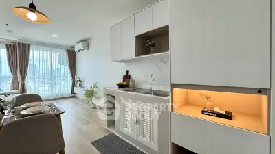 Modern open-plan kitchen and dining area with sleek cabinetry and city view.