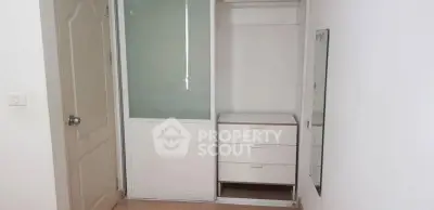 Minimalist bedroom with sliding closet and mirror, perfect for modern living.
