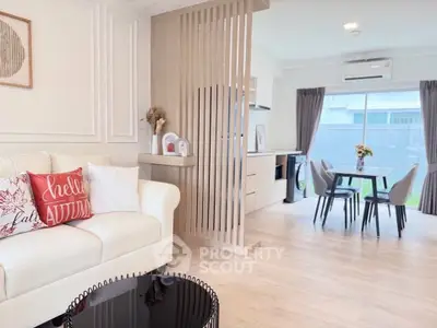 Modern open-plan living room with stylish decor and dining area, featuring natural light and contemporary design.