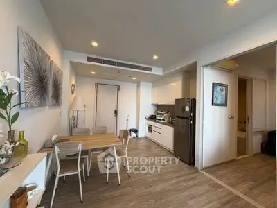 Modern open-layout kitchen and dining area with stylish decor and wooden flooring.
