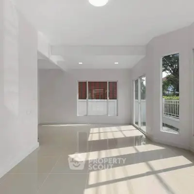 Spacious sunlit living room with large windows and glossy tiled floors