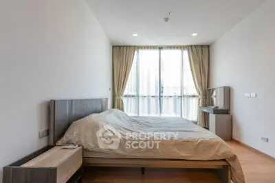 Spacious bedroom with modern furnishings and large window for natural light.
