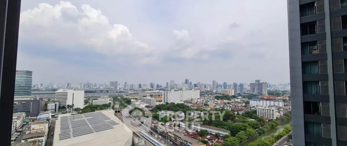 Stunning cityscape view from high-rise building balcony, showcasing urban skyline and lush greenery.
