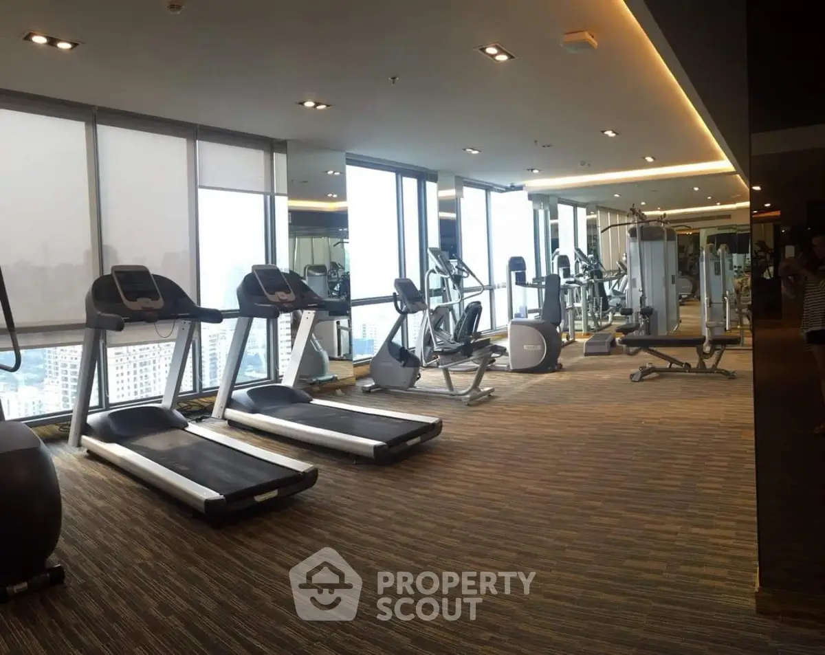 Spacious modern gym with city view in luxury building