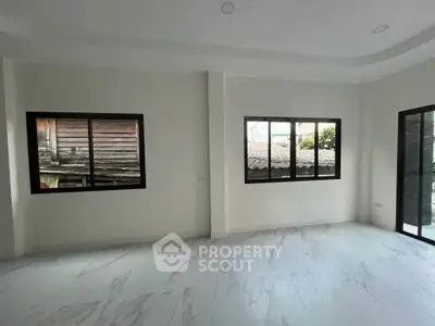 Spacious modern living room with large windows and elegant marble flooring
