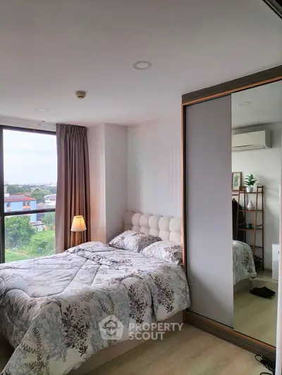 Cozy bedroom with large window and scenic view, featuring modern decor and ample natural light.