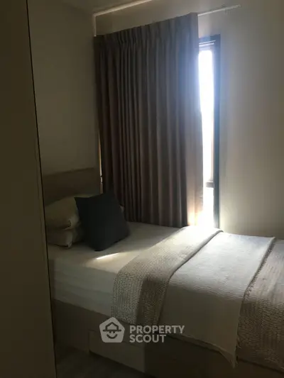 Cozy bedroom with natural light and elegant curtains in modern apartment.