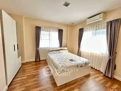 Spacious bedroom with natural light, modern furniture, and elegant curtains.