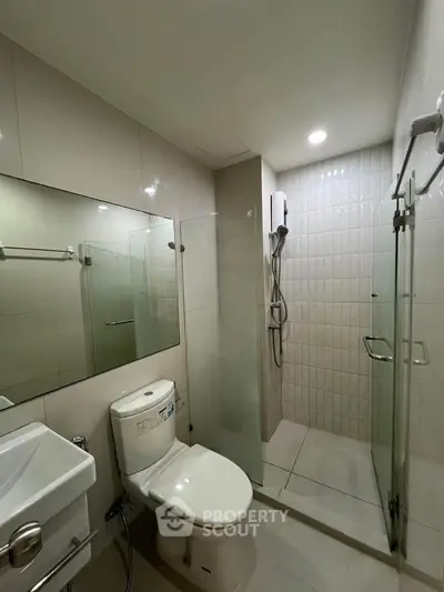 Modern bathroom with glass shower enclosure and sleek fixtures.