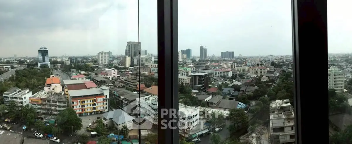 Panoramic cityscape view from high-rise building window showcasing urban skyline.