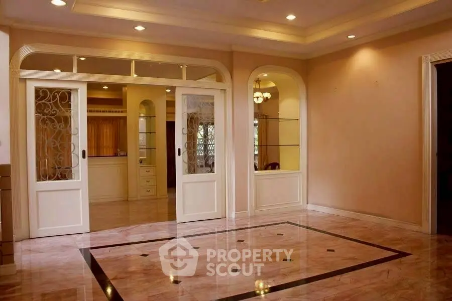 Elegant living room with marble flooring and sliding doors in a spacious interior.
