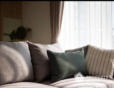 Cozy living room with stylish sofa and elegant curtains in natural light.