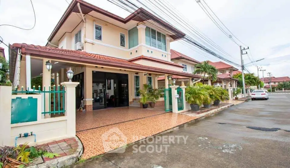 Charming two-story house with tiled driveway and lush greenery in a serene neighborhood.