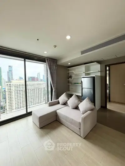 Modern living room with city view, featuring a cozy sofa and sleek shelving unit, perfect for urban living.