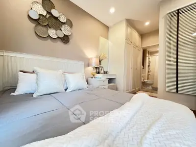 Cozy bedroom with elegant decor and soft lighting, featuring a comfortable bed and stylish wall art.