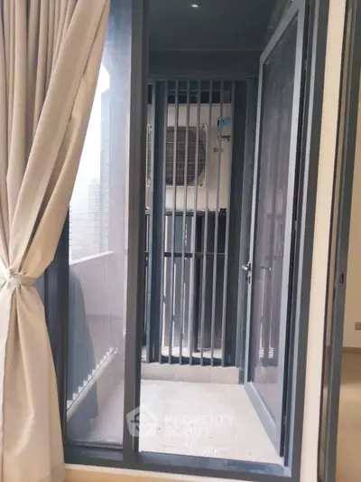 Modern apartment balcony with sliding glass doors and air conditioning unit