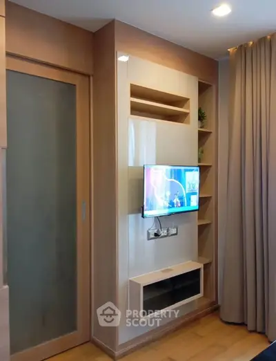 Modern living room with sleek TV setup and wooden accents