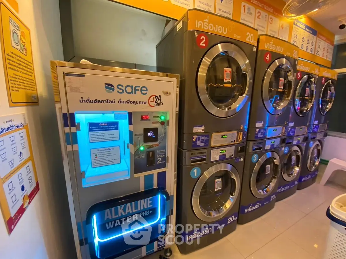 Modern laundry room with multiple washing machines and alkaline water dispenser.
