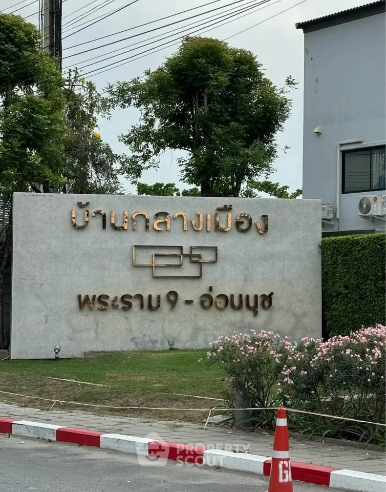 Modern real estate development entrance with stylish signage and landscaping.