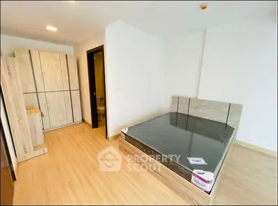 Modern bedroom with wooden flooring and sleek furniture in a bright apartment