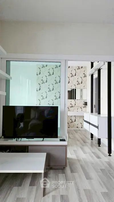 Modern living room with sleek TV stand and stylish wallpaper accent wall.