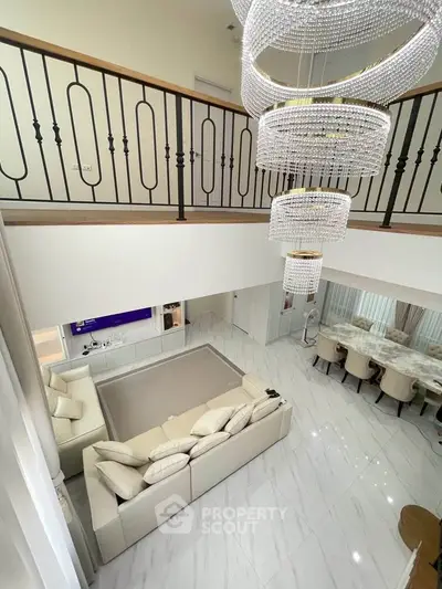 Luxurious two-story living room with elegant chandeliers and modern decor