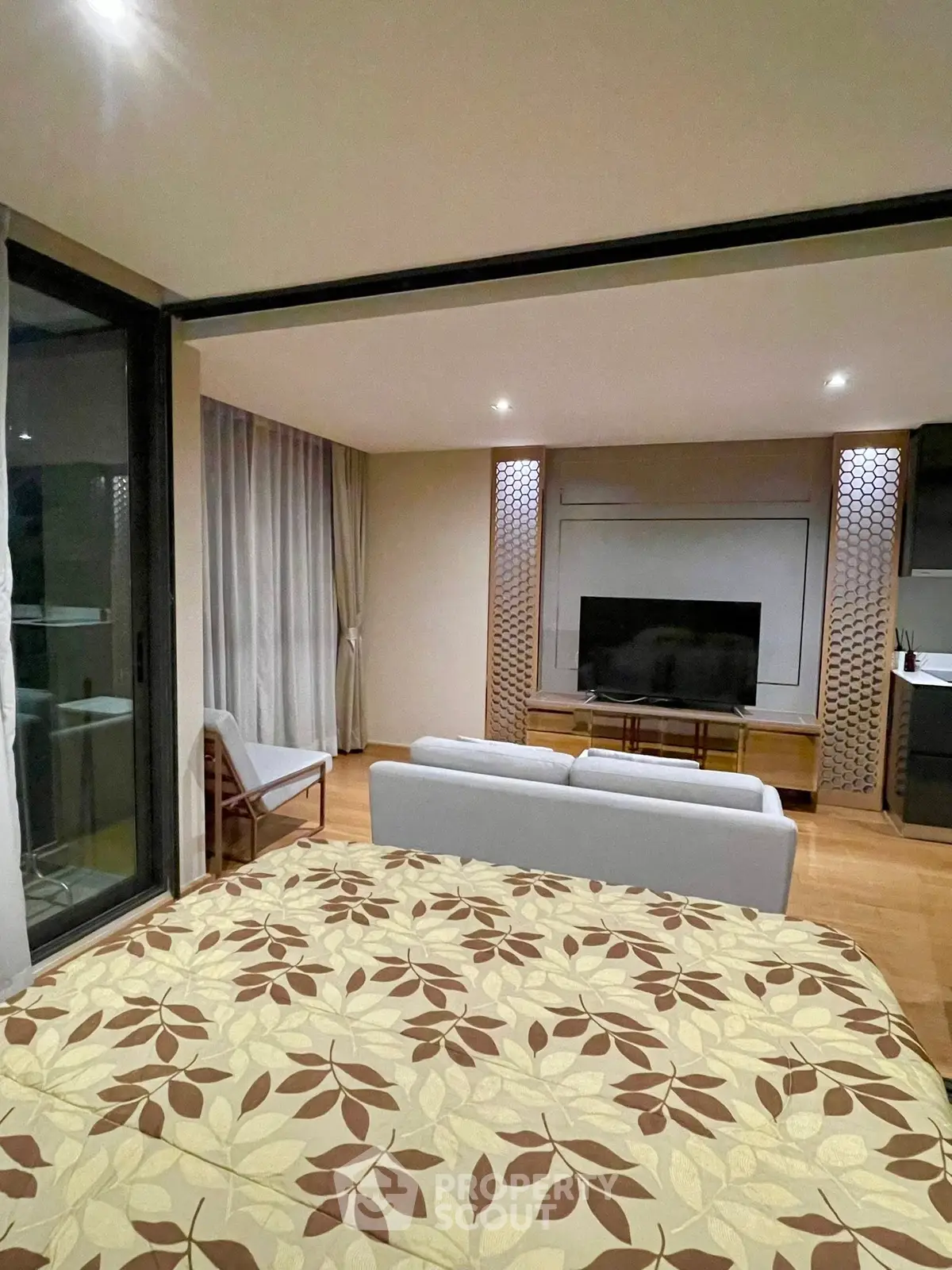 Modern living room with stylish decor and large TV, featuring a cozy seating area and elegant lighting.