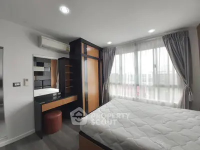 Modern bedroom with large window and stylish furniture in a bright apartment