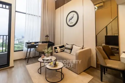 Modern living room with stylish decor and large windows offering city views