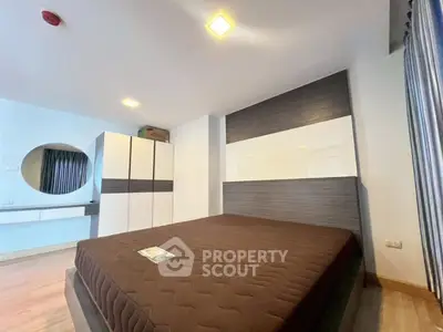 Spacious modern bedroom with stylish decor and ample storage in a contemporary apartment.