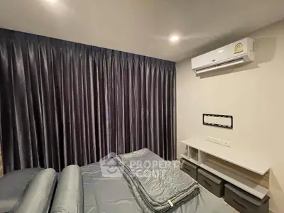 Modern bedroom with sleek design and air conditioning, featuring dark curtains and minimalist furniture.