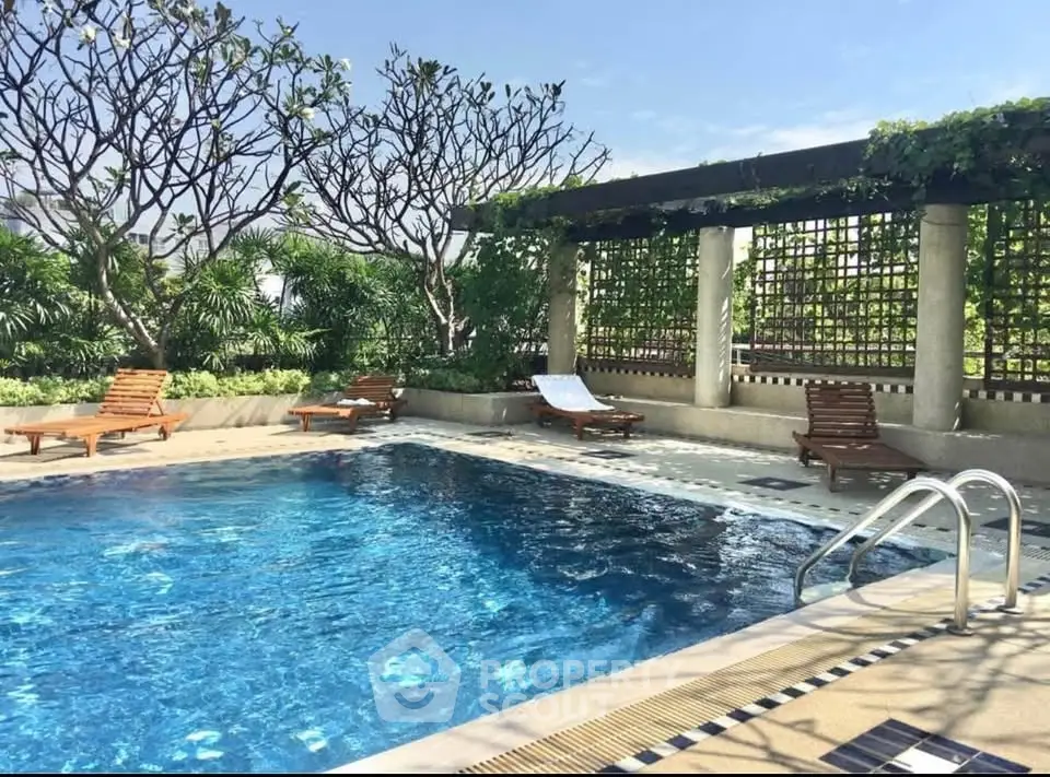 Luxurious rooftop pool with lush greenery and sun loungers, perfect for relaxation.