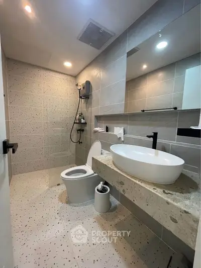 Modern bathroom with sleek design and elegant fixtures, featuring a stylish sink and spacious shower area.