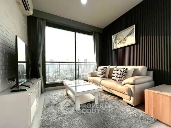 Modern living room with large window and stylish decor in high-rise apartment.