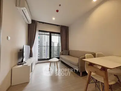 Modern living room with sleek furniture and city view from balcony in high-rise apartment.
