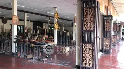 Spacious open-air gallery with traditional wooden carvings and artifacts, perfect for cultural enthusiasts.